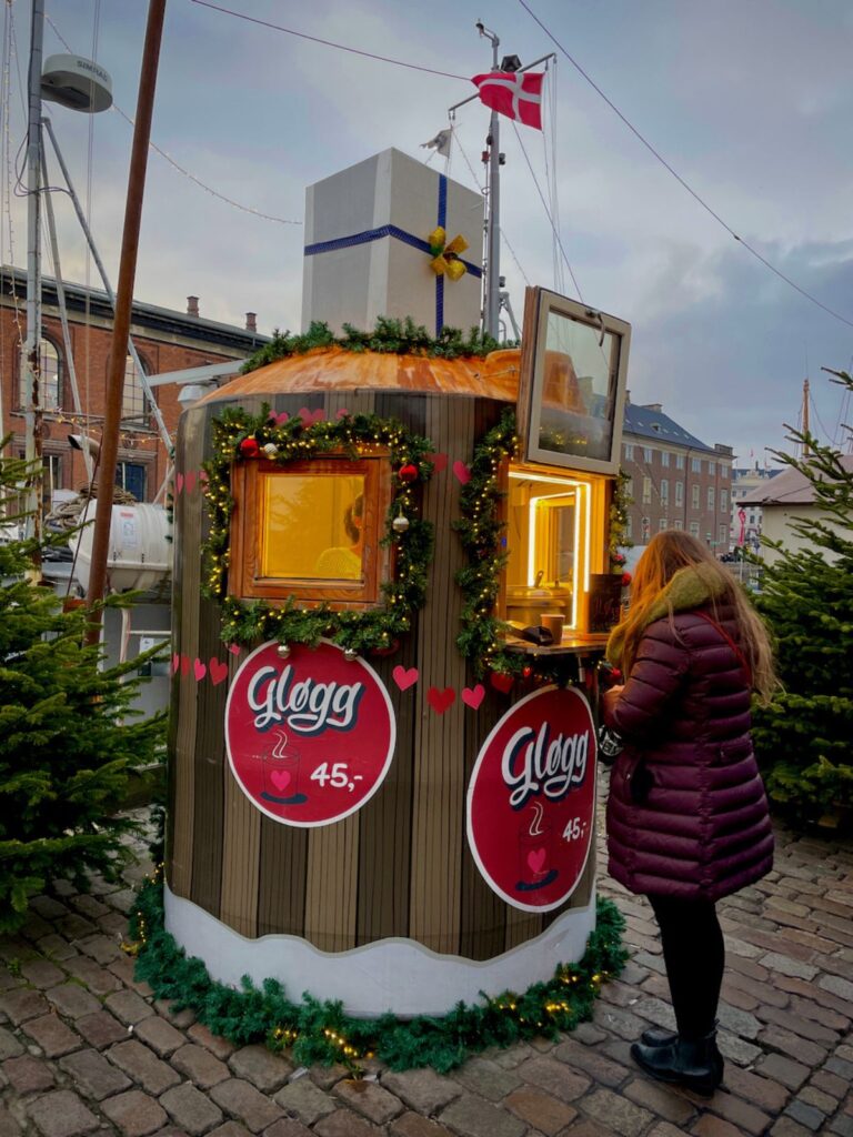 A woman buying Danish Christmas drink called Gløgg at Nyhavn