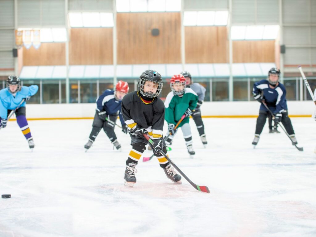 A group of boys playing ice hockey in indoor ice skating rinks in Copenhagen, Denmark