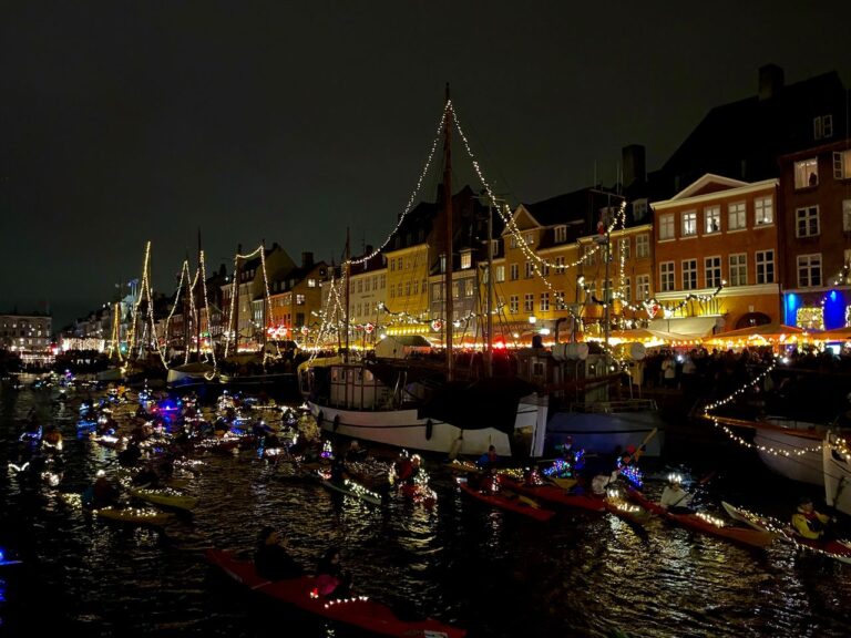 The Copenhagen canals are glowing with lights on the kayaks and decorations on the building on the Santa Lucia Parade, Copenhagen