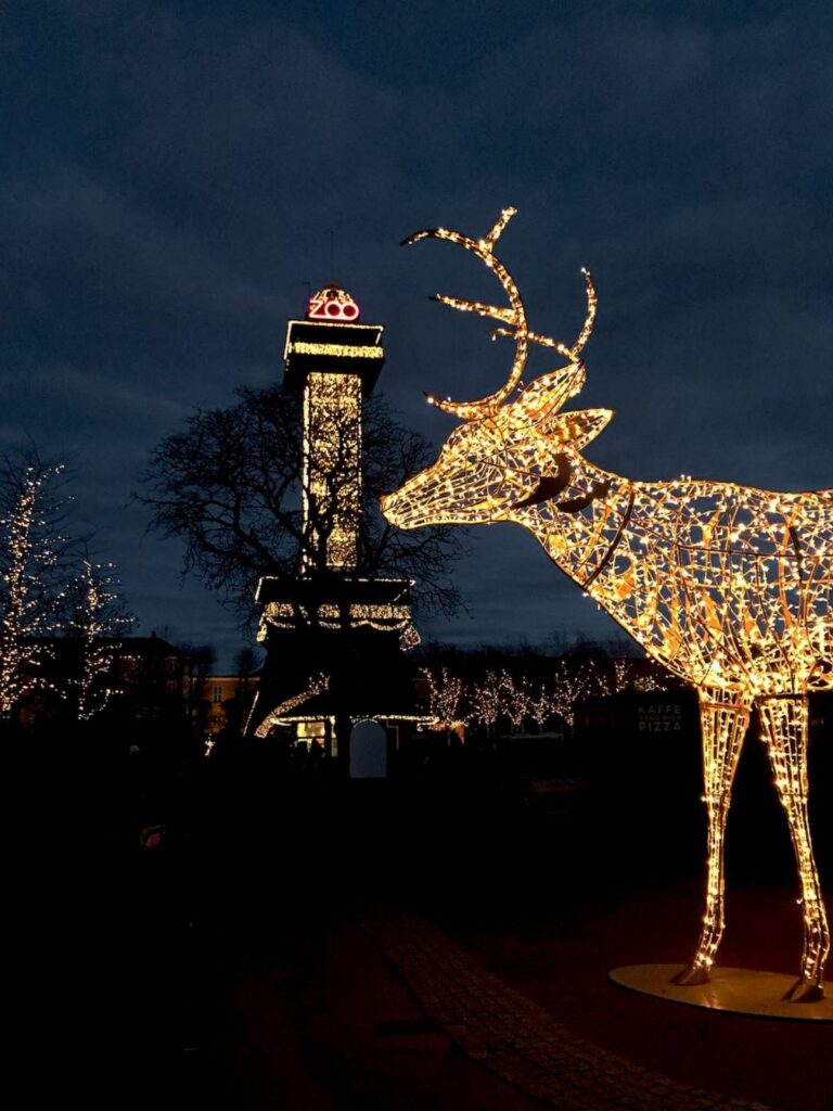 Decorated Copenhagen Zoo clock tower during Christmas with a raindeer statue covered in festive lights