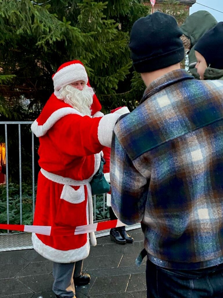 Julemanden or Santa Claus distributing chocolates to the kids