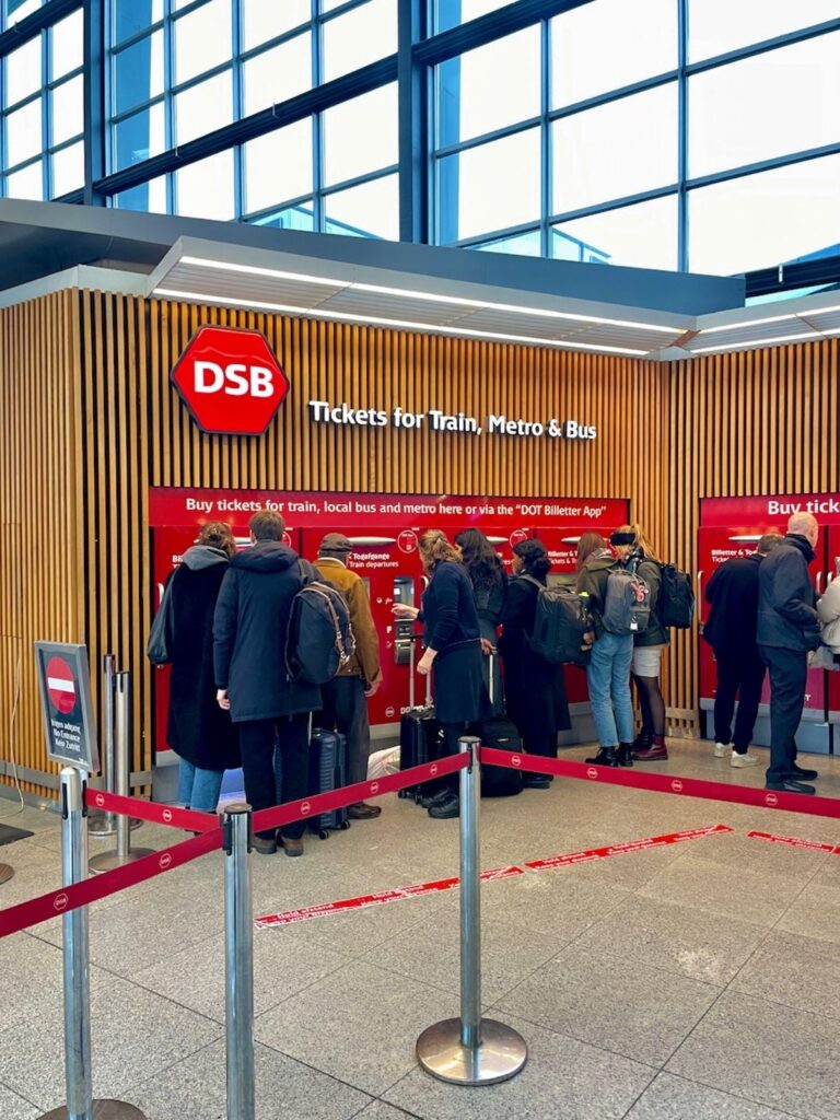 People buying DSB tickets at counters to travel from Copenhagen Airport to city