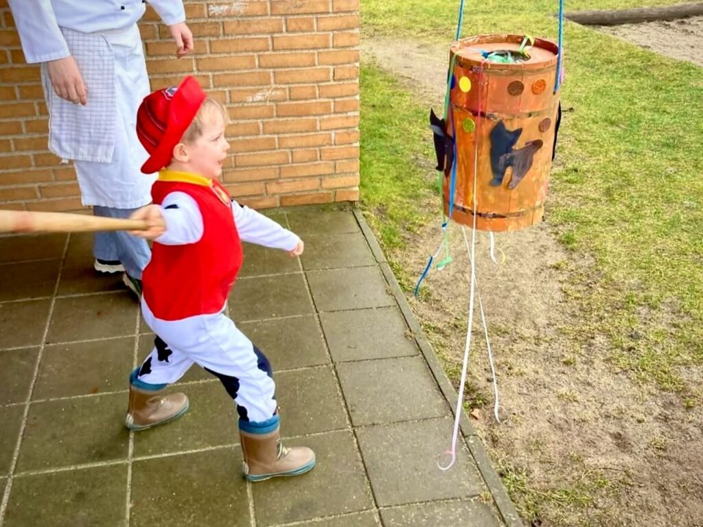 Fastalavn in Denmark - Slå katten af tønden - A boy beating a wooden barrel with stick