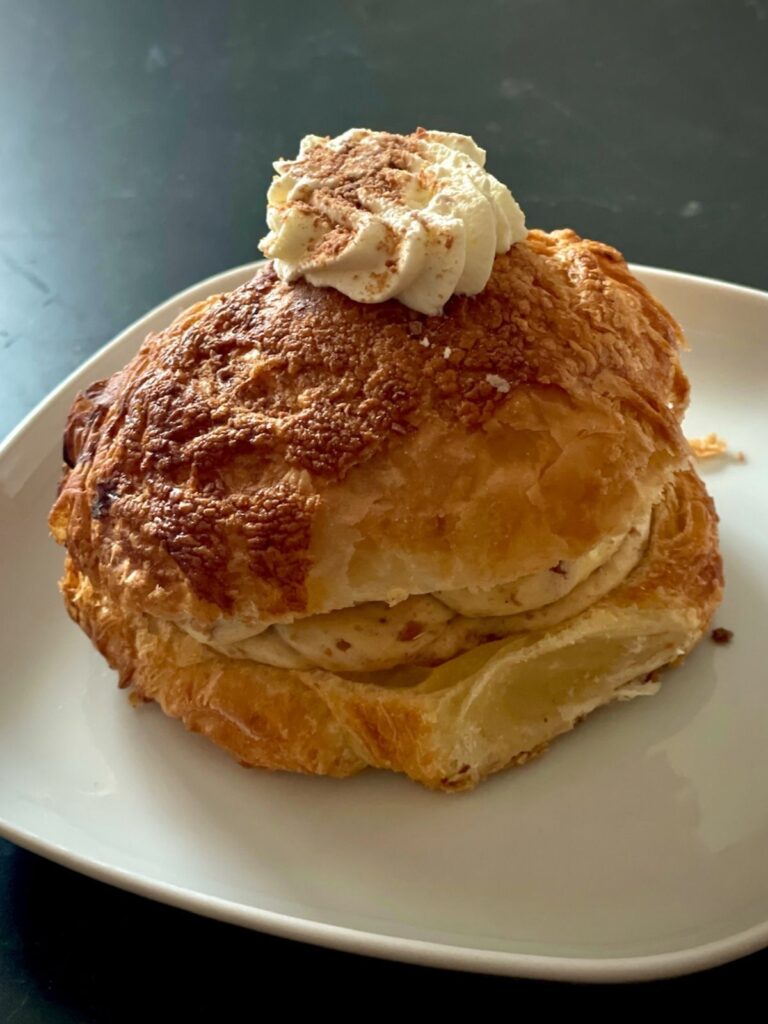 Fastelavnboller - Danish cream bun topped with whipped cream on a plate.