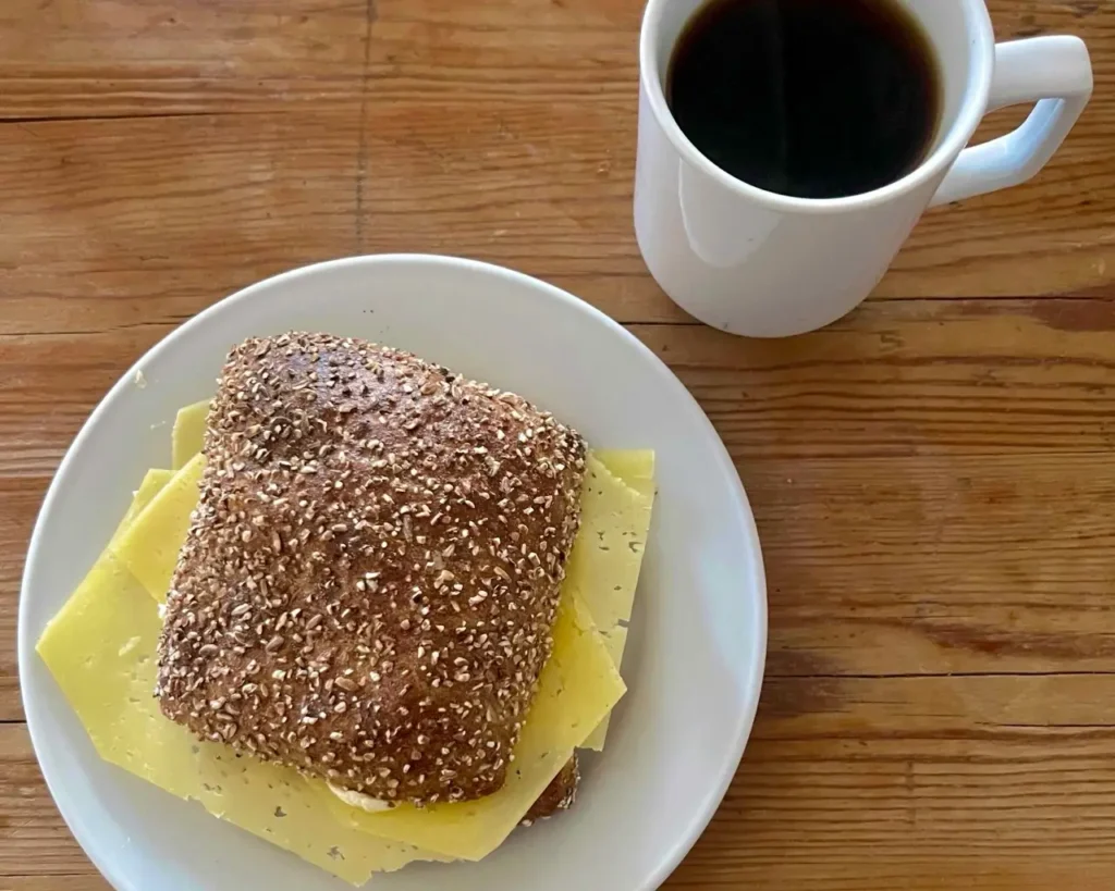 Danish BMO - Rundstykkeror round bun with butter and cheese along with a cup of coffee