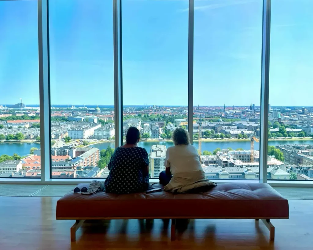 Two people admiring the view of Copenhagen from the Mersk tower viewpoint